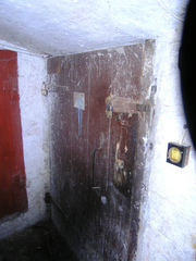 Drzwi aresztu z widocznymi judaszami i śladami po typowym zamku